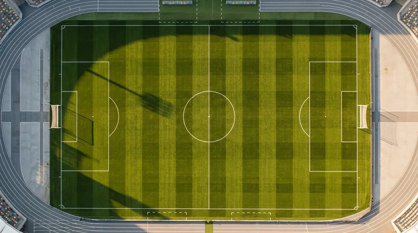 Vista aérea de un campo de fútbol profesional con césped natural y líneas marcadas durante una jornada de Champions League
